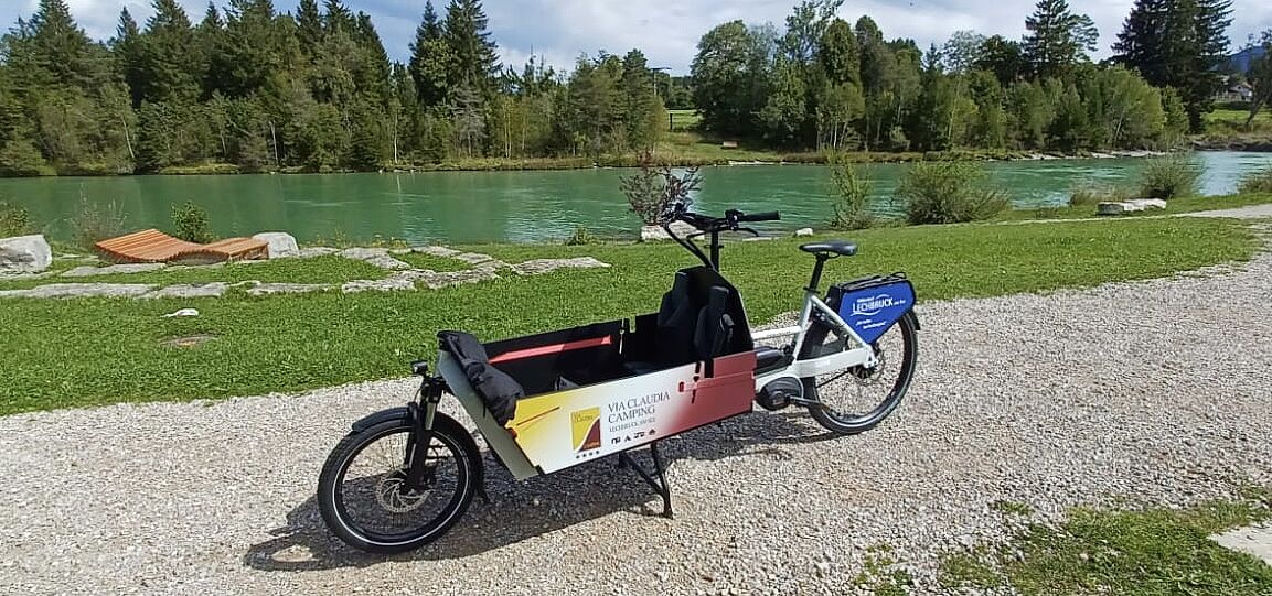 Lastenrad am Lechufer Lastenrad am Weg. Fluss im Hintergrund