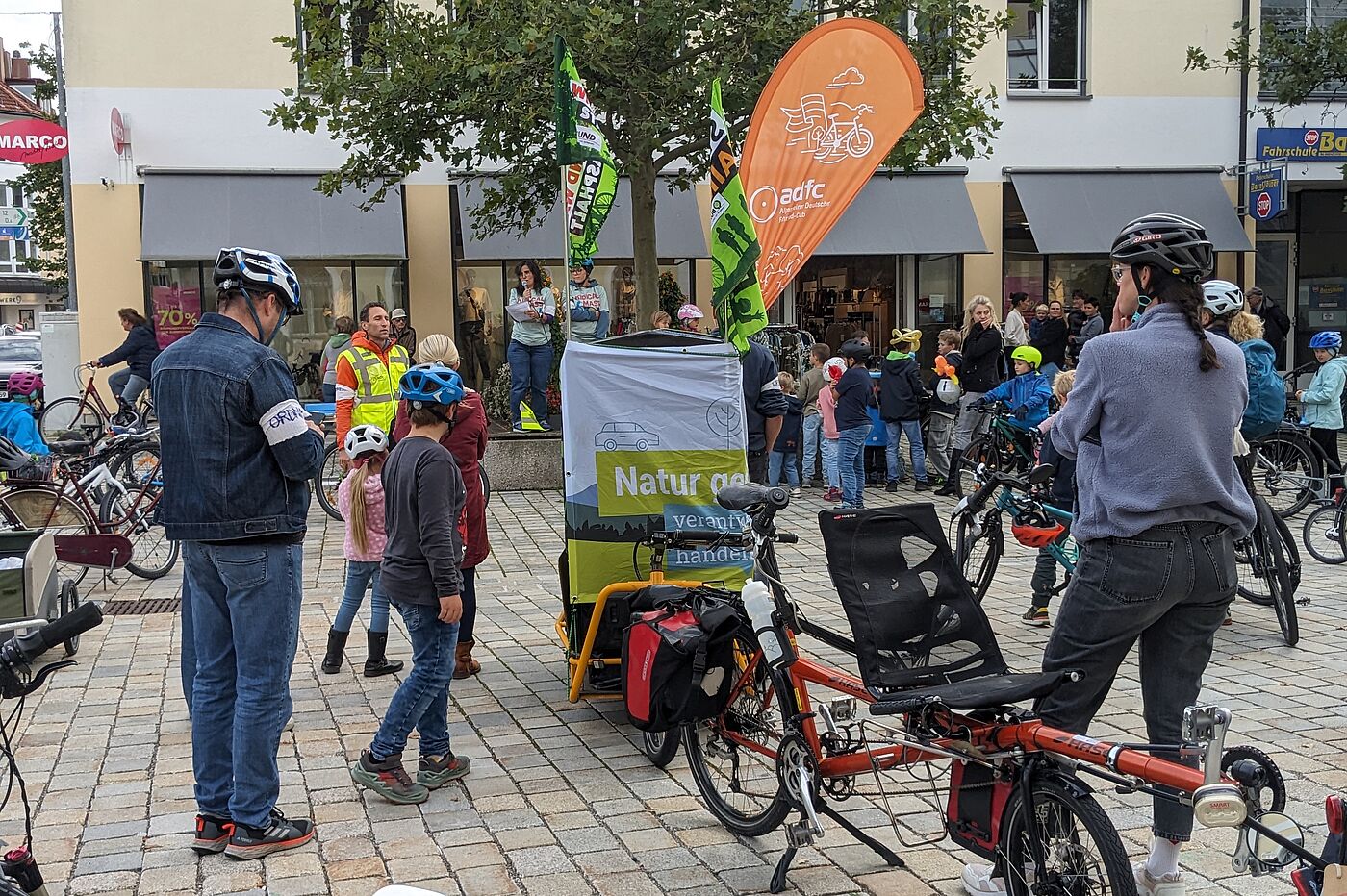 KM MOD Begrüßung Radler:innen auf einem Platz