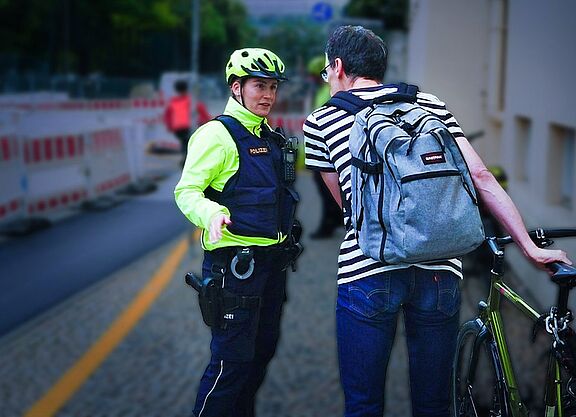 Polizistin spricht mit Radfahrer